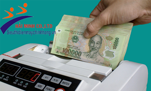 Xấp tiền được đặt trong phễu của máy